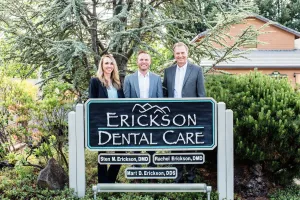 Erickson Dental Care Team in front of practice sign
